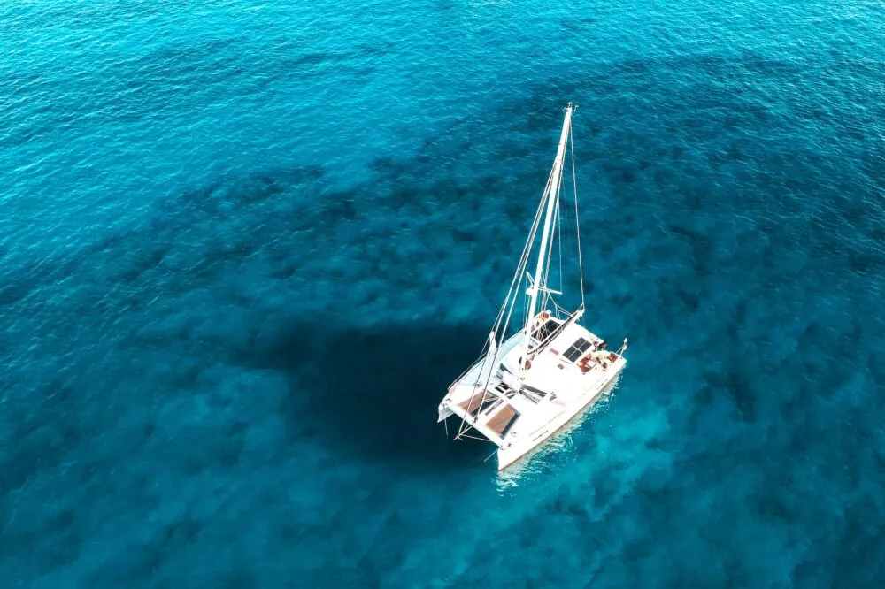 Witte catamaran op de blauwe zee van Hvar, Kroatië.