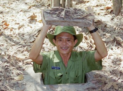 Man kruipt uit in schuilkelder van de Cu Chi Tunnels in Vietnam