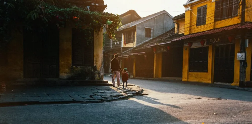 Vader en kind door de kleurrijke straten van Hoi An in Vietnam