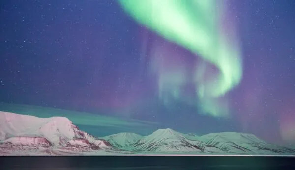Noorderlicht boven besneeuwde bergen in Spitsbergen