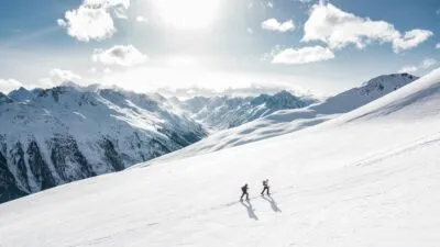 Mensen lopen berg op in sneeuw