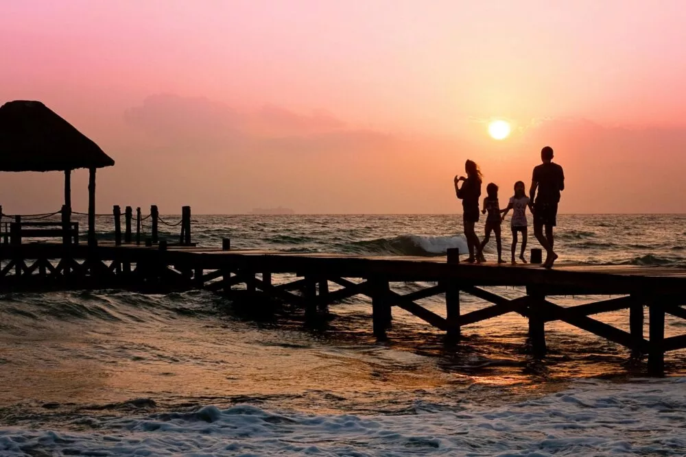 Familie op een pier tijdens zonsondergang