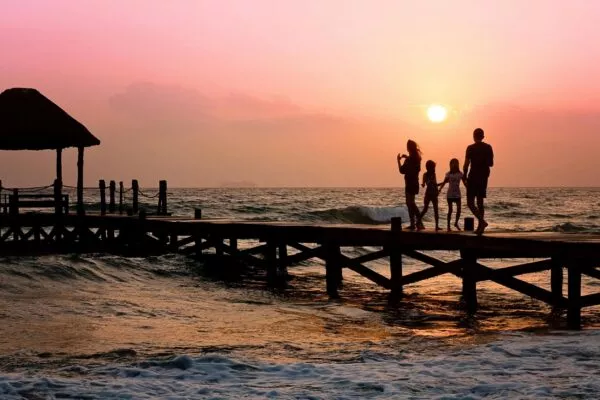Familie op een pier tijdens zonsondergang