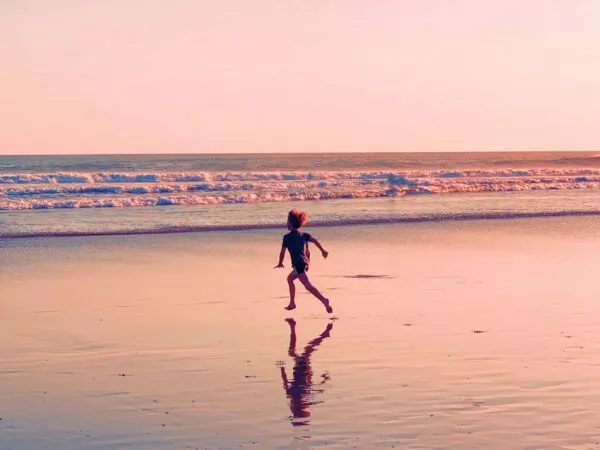 Jongen rent de zee in