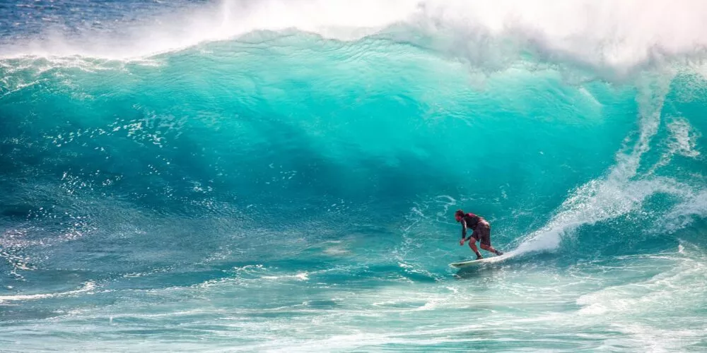 Man surfen op golf in zee
