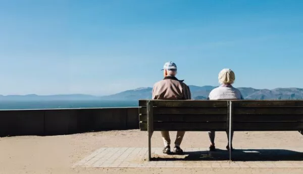 Ouderen op bankje met uitzicht op baai