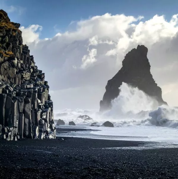 Rots in zee bij zwarte stranden van Vik, IJsland.
